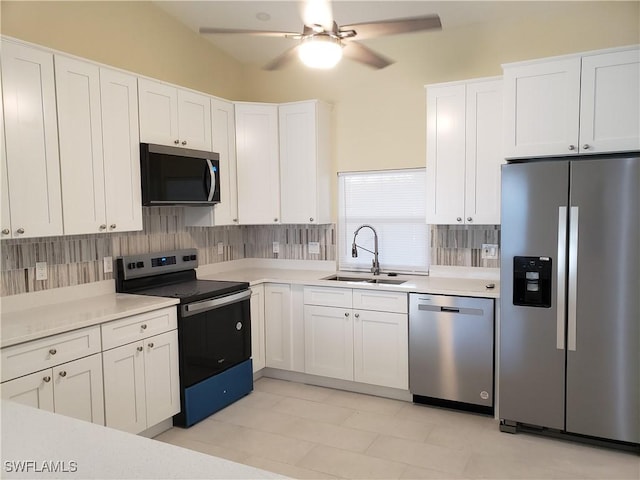 kitchen with sink, backsplash, white cabinets, and appliances with stainless steel finishes