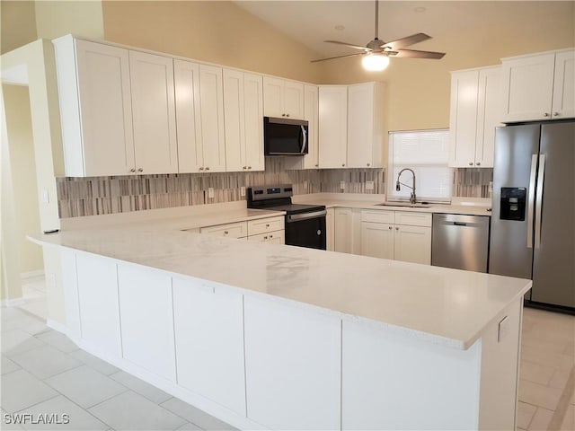 kitchen featuring sink, tasteful backsplash, appliances with stainless steel finishes, kitchen peninsula, and white cabinets