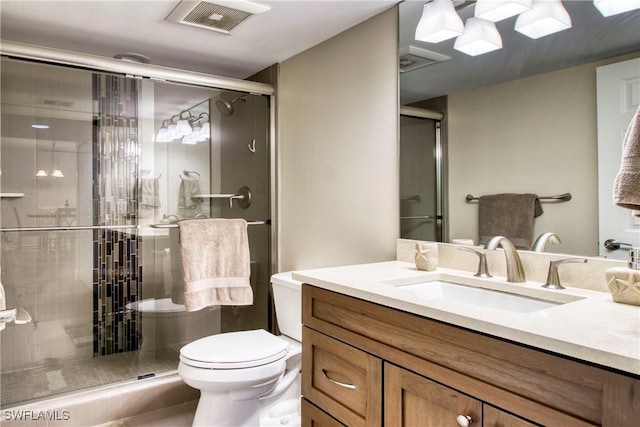 bathroom with vanity, toilet, and an enclosed shower