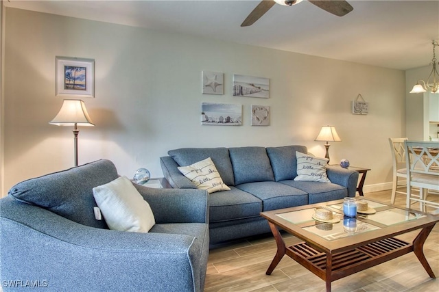 living room with ceiling fan with notable chandelier