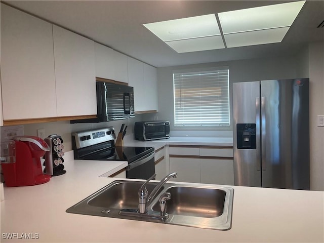 kitchen featuring white cabinetry, stainless steel appliances, and sink