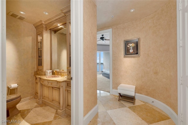 bathroom featuring crown molding, ceiling fan, vanity, and toilet