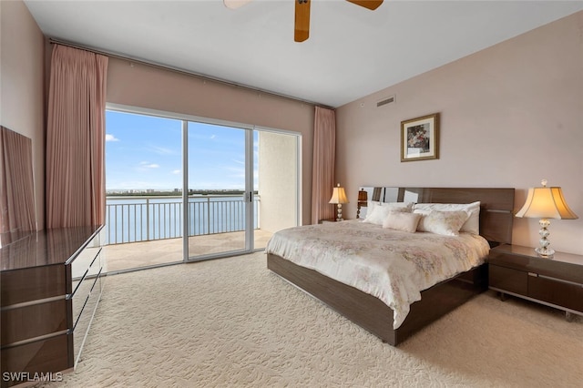 bedroom featuring a water view, ceiling fan, access to exterior, and carpet