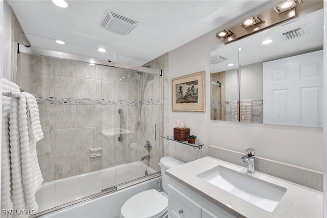 full bathroom featuring toilet, vanity, and shower / bath combination with glass door