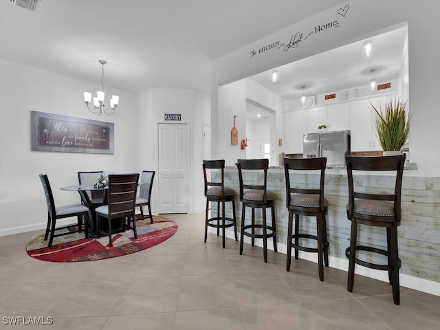 dining area with light tile patterned flooring and a notable chandelier