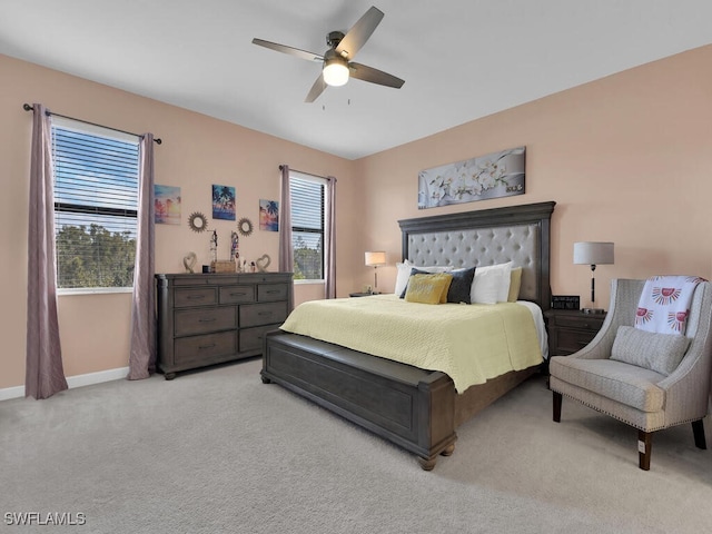 carpeted bedroom with multiple windows and ceiling fan