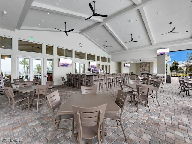 dining area featuring beamed ceiling, ceiling fan, and high vaulted ceiling