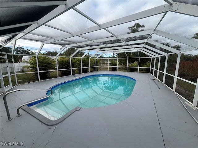 view of swimming pool featuring a lanai and a patio