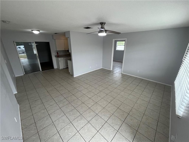 unfurnished living room featuring light tile patterned flooring, ceiling fan, and a textured ceiling