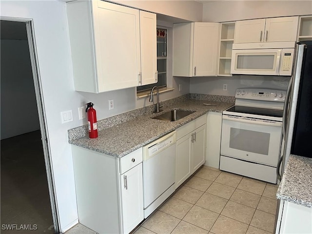 kitchen with sink, light tile patterned floors, white appliances, light stone countertops, and white cabinets