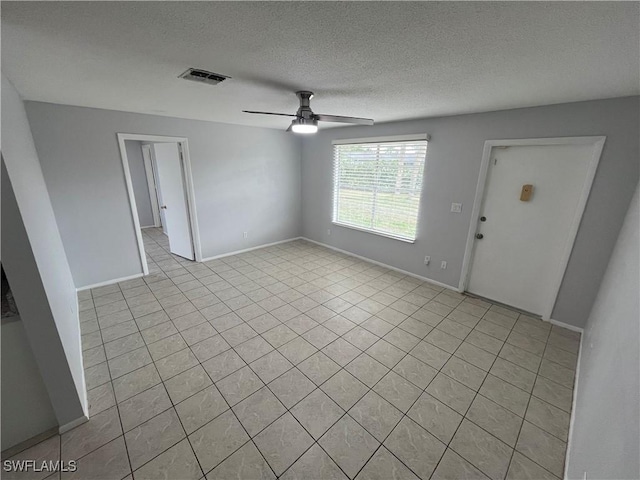 tiled spare room featuring ceiling fan and a textured ceiling