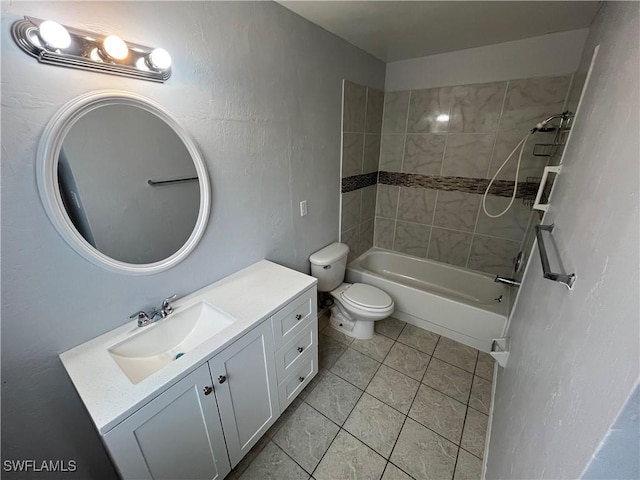 full bathroom with tile patterned flooring, vanity, tiled shower / bath combo, and toilet