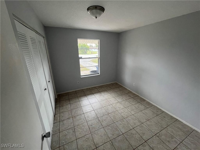 unfurnished bedroom featuring light tile patterned floors and a closet