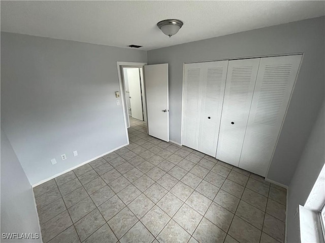 unfurnished bedroom featuring a closet and light tile patterned floors