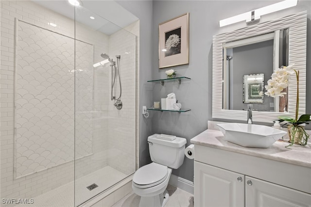 bathroom featuring vanity, toilet, tile patterned flooring, and a tile shower