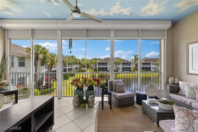 sunroom / solarium with ceiling fan and a water view