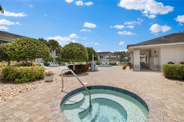 view of pool with a hot tub and a patio area