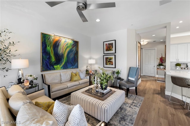 living room with wood-type flooring and ceiling fan