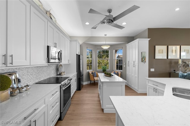 kitchen with white cabinetry, hanging light fixtures, and stainless steel appliances