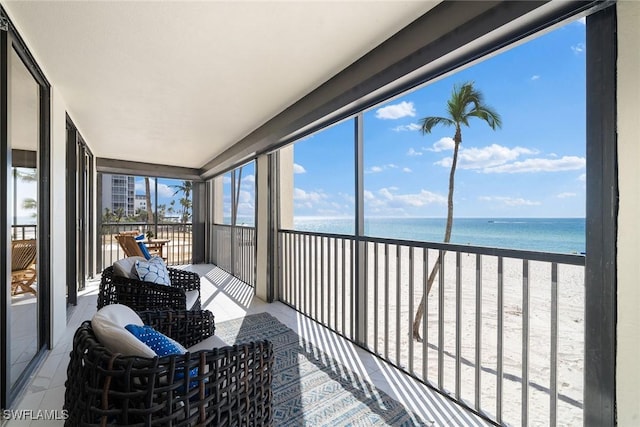 sunroom / solarium with a water view and a view of the beach