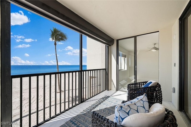 balcony with a water view and a view of the beach