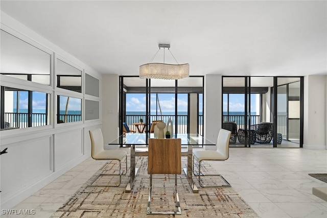 dining area featuring a water view, expansive windows, and plenty of natural light