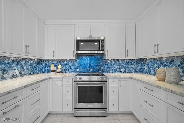 kitchen with light stone counters, appliances with stainless steel finishes, and white cabinets