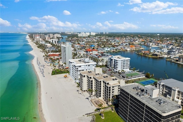 birds eye view of property with a water view and a beach view