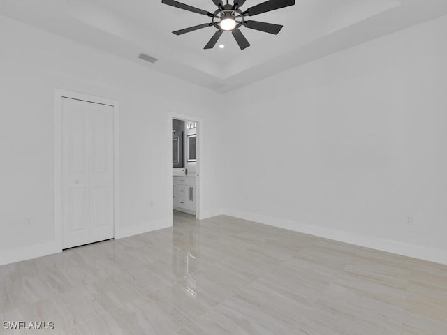 unfurnished room featuring ceiling fan and a tray ceiling