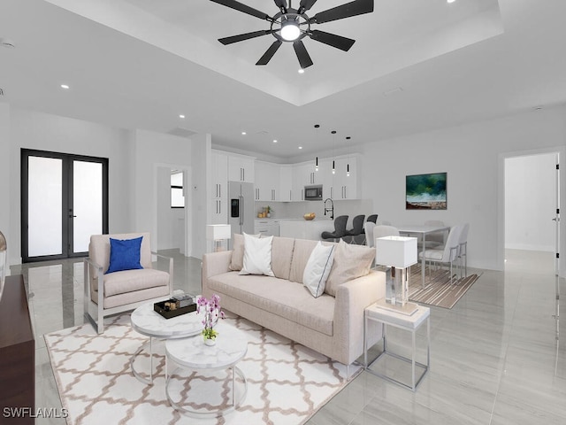 living room with french doors, ceiling fan, and a tray ceiling