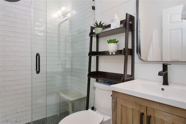 bathroom featuring vanity, an enclosed shower, and toilet