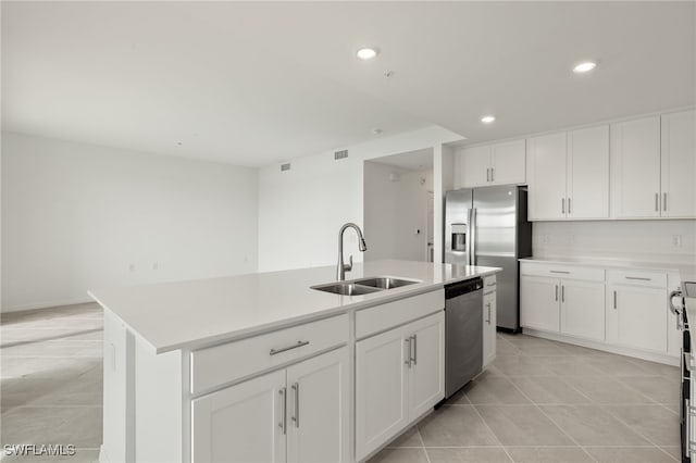 kitchen featuring stainless steel appliances, a kitchen island with sink, sink, and white cabinets