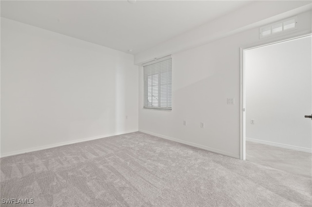 unfurnished room featuring light colored carpet