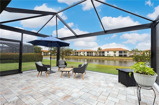 view of patio featuring a water view and glass enclosure