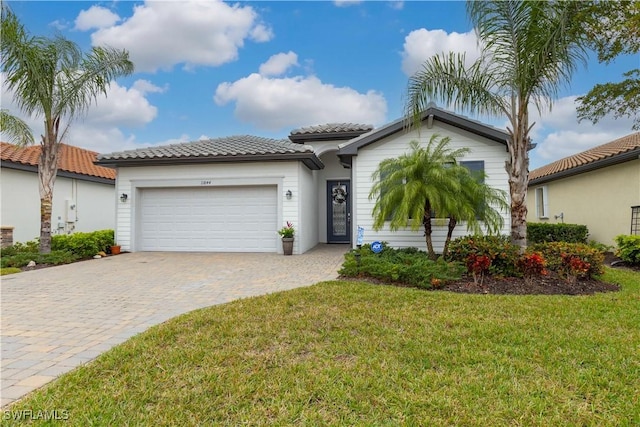 mediterranean / spanish house featuring a garage and a front yard