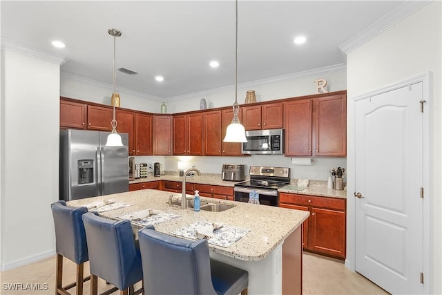 kitchen featuring stainless steel appliances, decorative light fixtures, sink, and a breakfast bar area