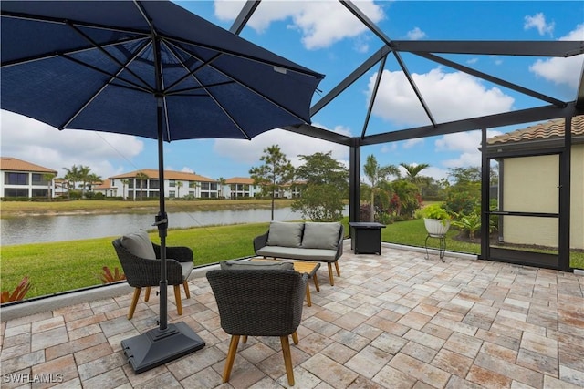 view of patio featuring a water view and glass enclosure