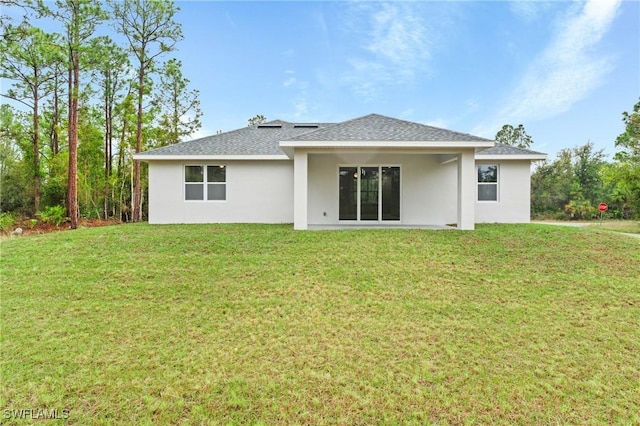 rear view of house featuring a lawn