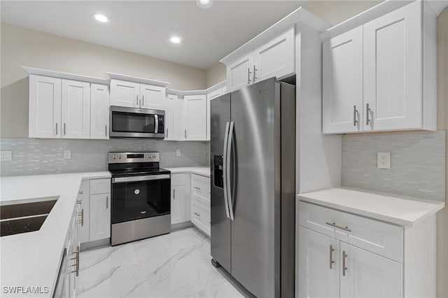 kitchen with white cabinetry, sink, tasteful backsplash, and stainless steel appliances