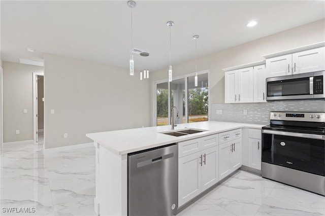 kitchen with sink, white cabinetry, hanging light fixtures, stainless steel appliances, and kitchen peninsula