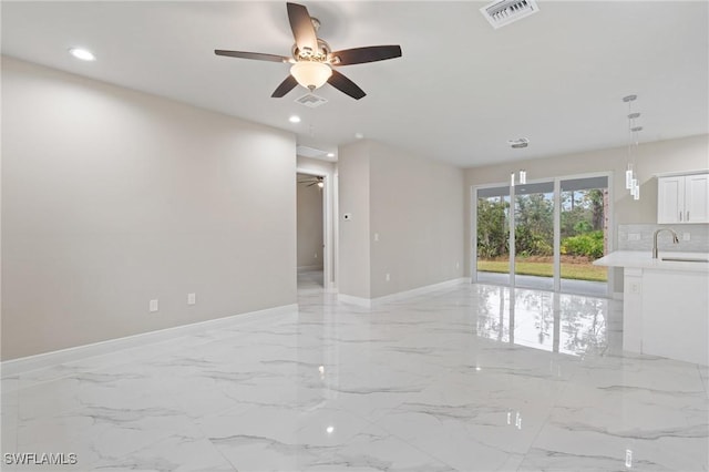 unfurnished living room with ceiling fan and sink