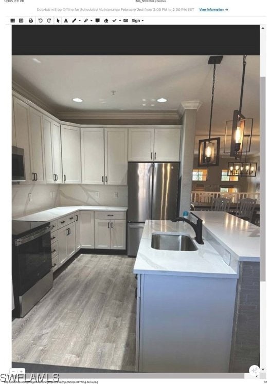 kitchen with sink, hanging light fixtures, appliances with stainless steel finishes, dark hardwood / wood-style flooring, and white cabinets