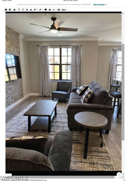 living room featuring wood-type flooring, plenty of natural light, and crown molding