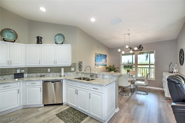 kitchen with sink, decorative light fixtures, vaulted ceiling, stainless steel dishwasher, and white cabinets