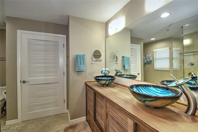 bathroom with tile patterned floors, vanity, toilet, and an enclosed shower