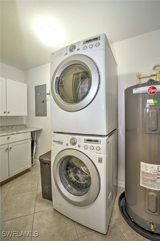 laundry room featuring water heater, electric panel, cabinets, stacked washer / drying machine, and light tile patterned flooring