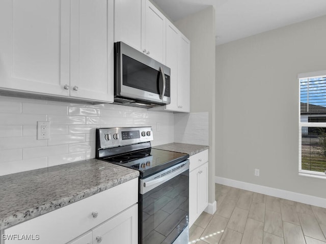 kitchen featuring white cabinetry, appliances with stainless steel finishes, plenty of natural light, and backsplash