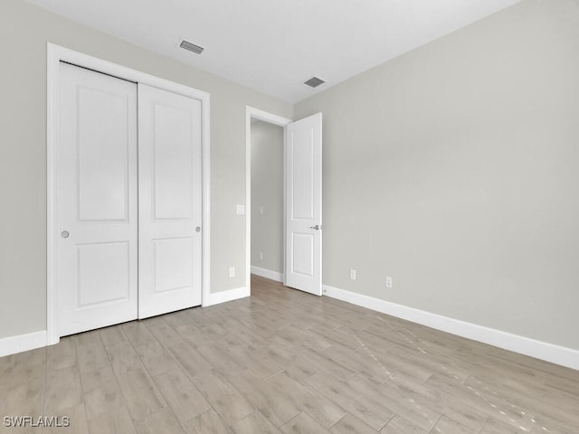 unfurnished bedroom featuring light wood-type flooring and a closet