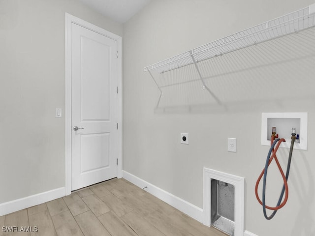 clothes washing area with washer hookup, light hardwood / wood-style floors, electric dryer hookup, and gas dryer hookup