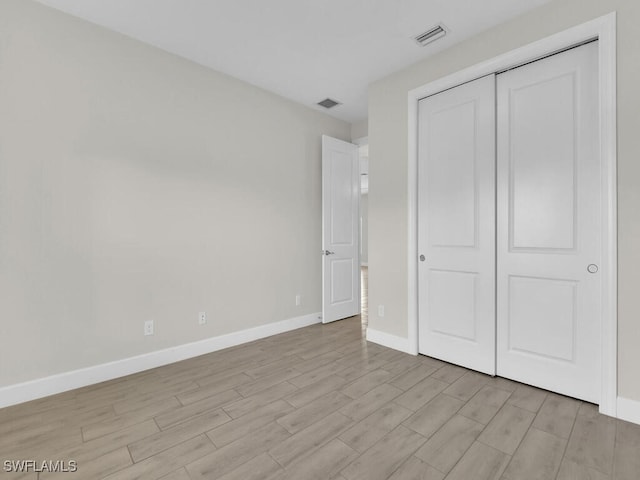 unfurnished bedroom with a closet and light hardwood / wood-style flooring